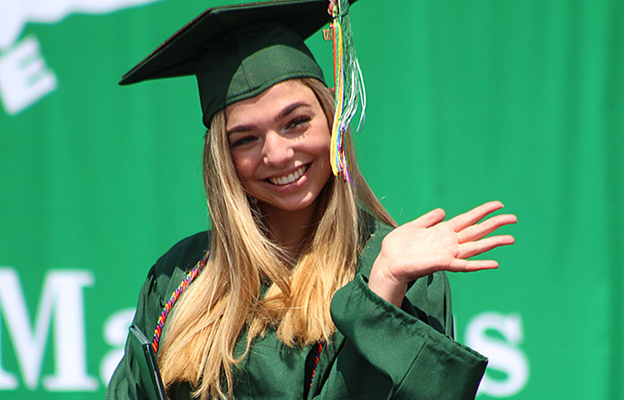 This is an image of a graduate waving