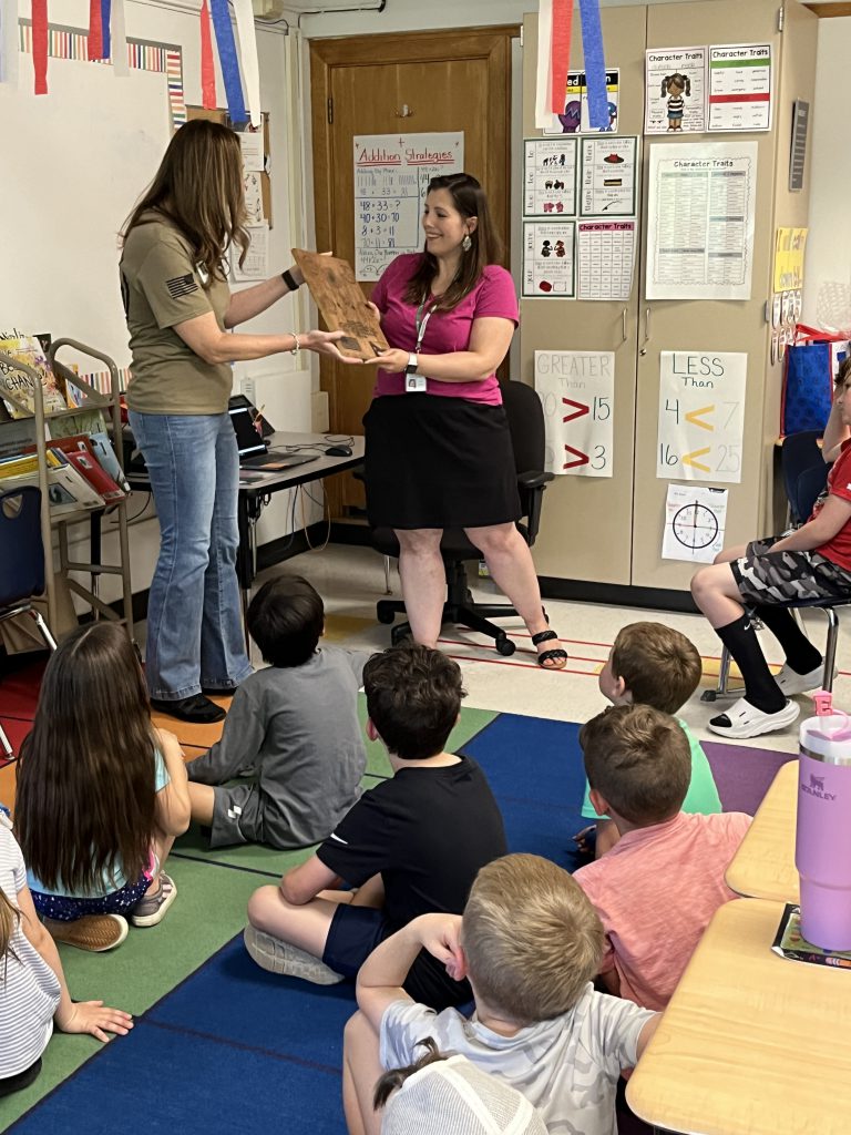 Mrs. Merritt's second grade class was awarded a plaque from Navy Reservist Jessica Serafin for their work in sending letters to military members overseas.