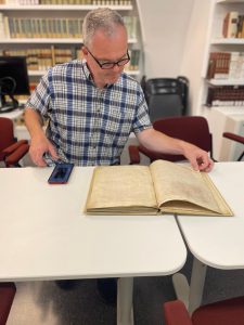 F-M Latin teacher Dr. Hunt examines a tenth century manuscript of St. Augustine's Confessions at the Biblioteca Angelica, the oldest public library in Italy. 