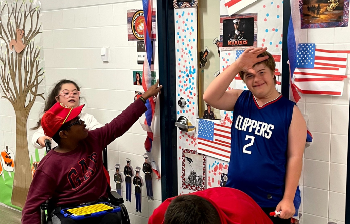 Students standing in front of a door that is decorated for the United States Marines